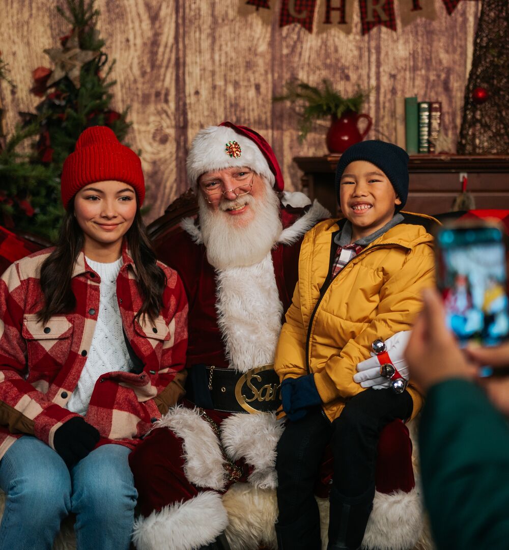 Kids sit with Santa at the Banff Christmas Market.
